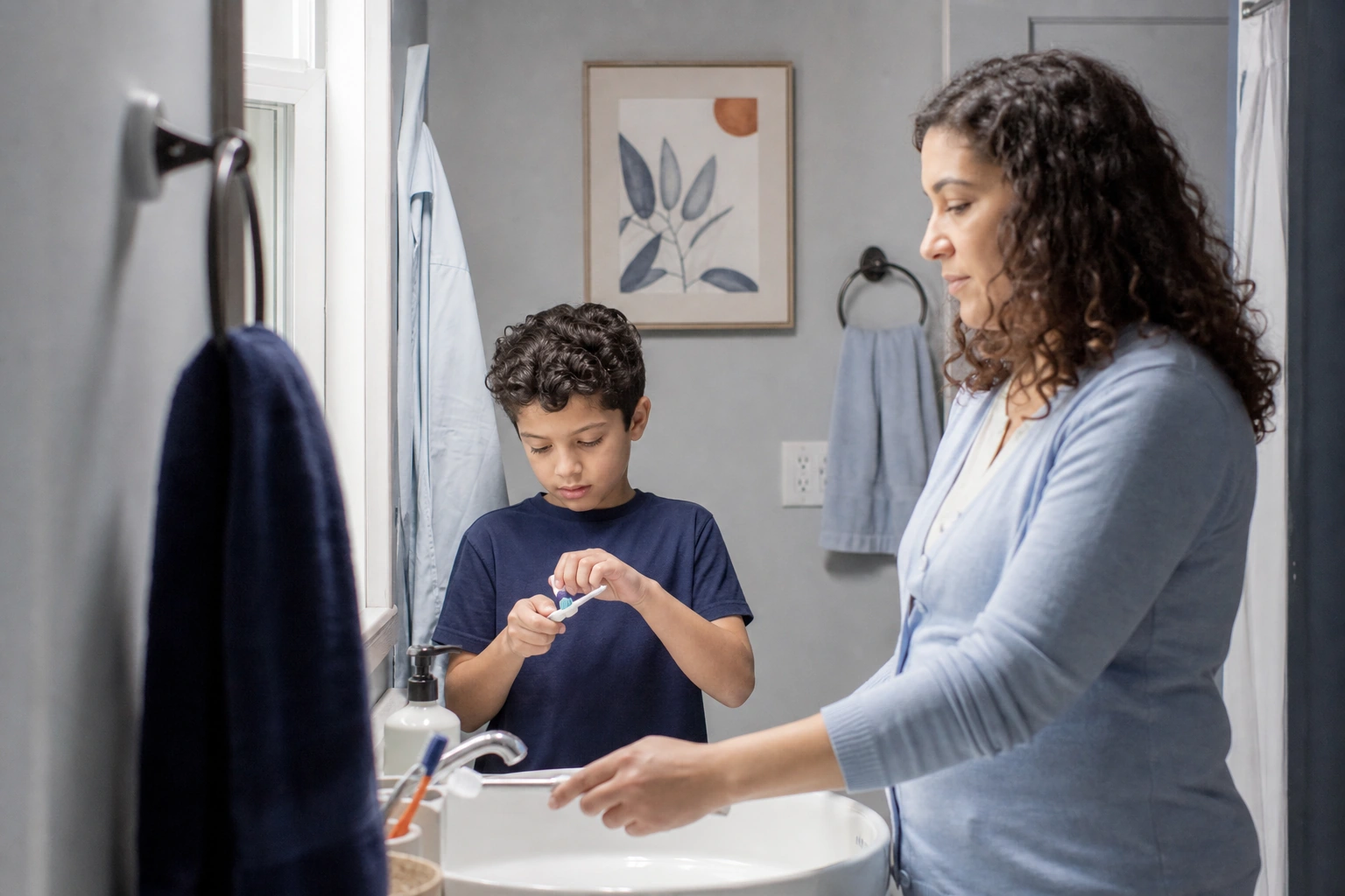 A mother and her eight-year-old son at their bathroom sink preparing toothbrushes before school.