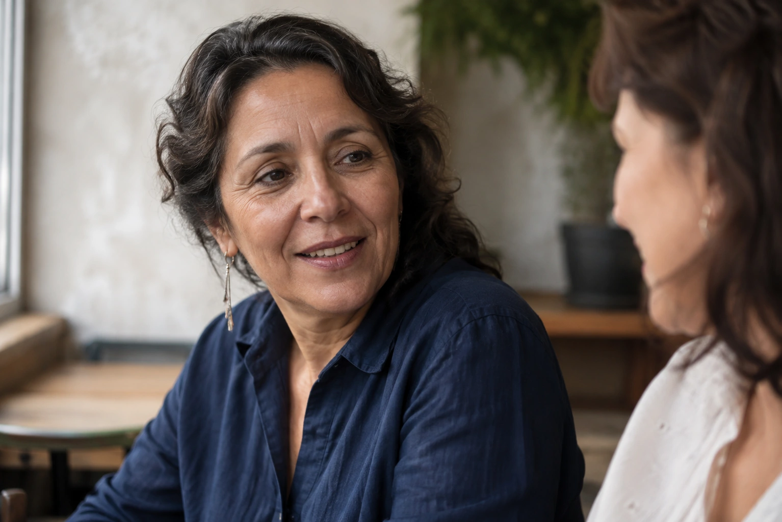 A 52-year-old Mexican American woman with visible laugh lines.