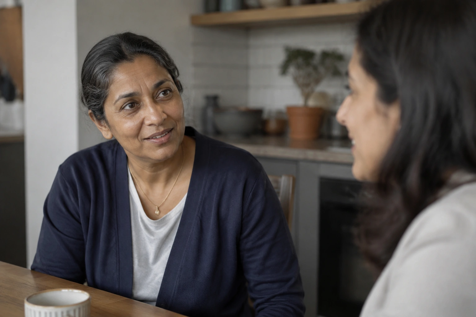 A middle-aged South Asian woman with a few gray strands.